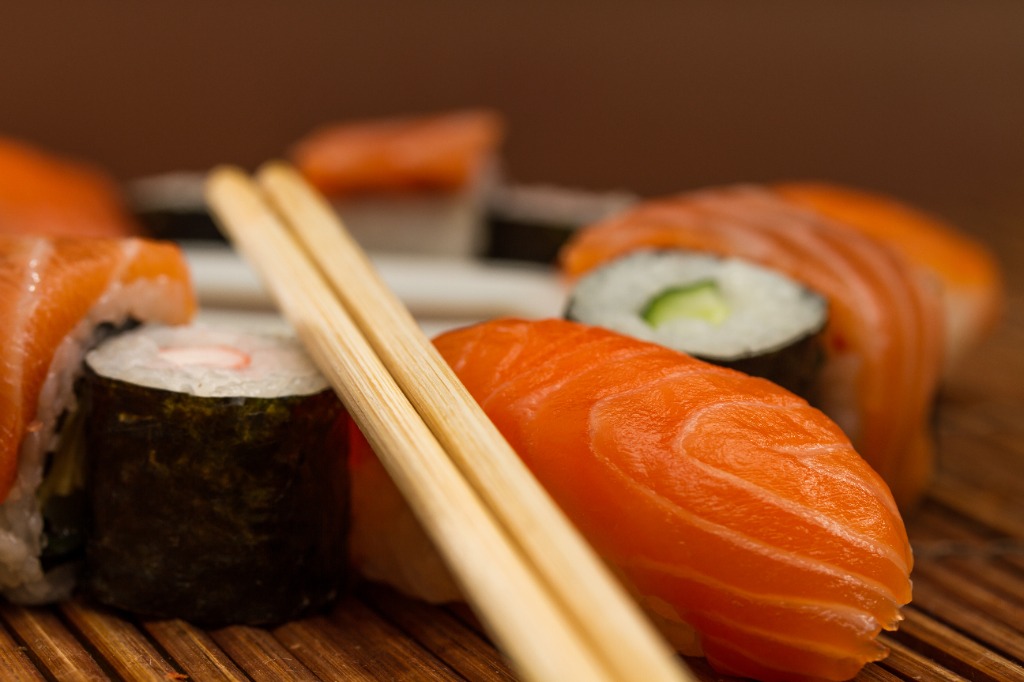 Variety of sushi held by chopsticks